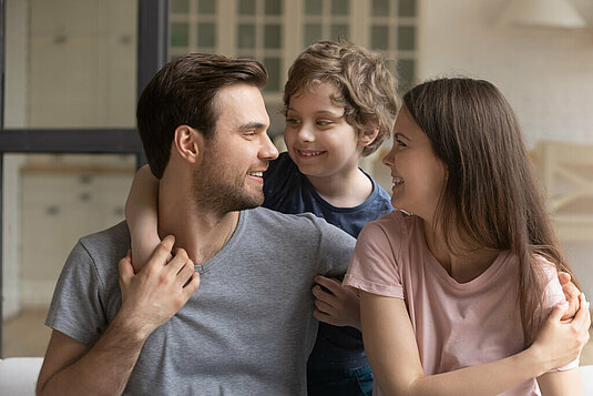 Haus-Familie-Wohnen-Serie-3-7 Vater mit Sohn und Tochter im Arm